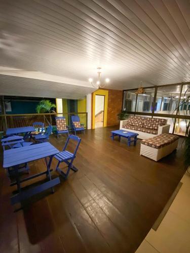 a large living room with blue tables and a couch at VOA Hotel Paraíso das Águas Bonito in Bonito