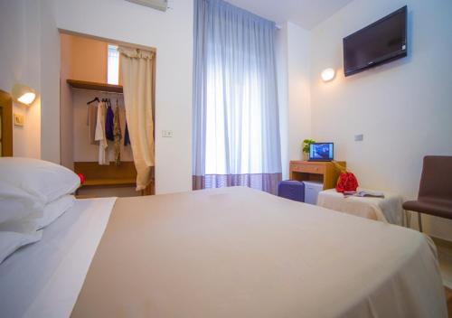 a bedroom with a large white bed and a window at Mediterraneo Hotel & Suites in Cattolica