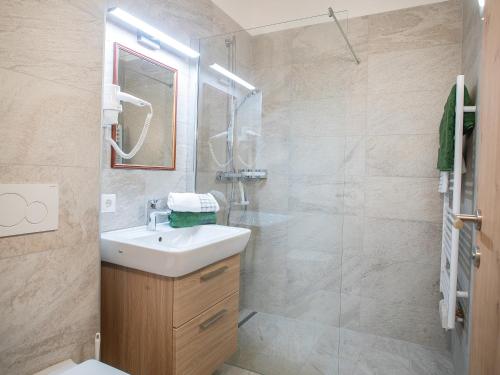 a bathroom with a sink and a shower at Gasthof Dorfwirt Sandgruber Ges.m.b.H in Pertisau