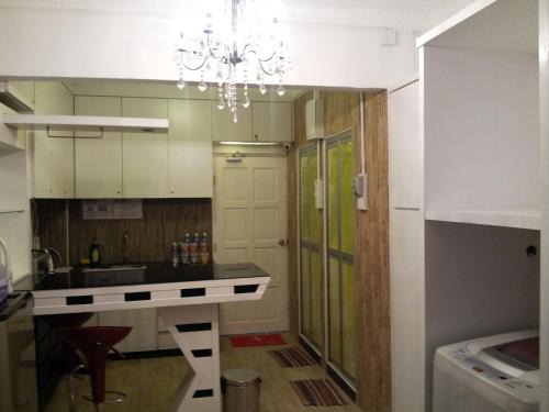 a kitchen with a counter and a chandelier at Fastbook Bendera Home 8 & 10pax in Ayer Itam
