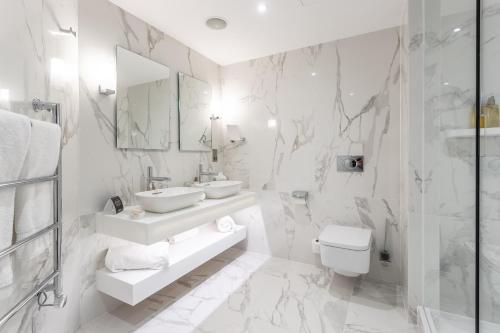a white bathroom with a sink and a toilet at The Scotsman Hotel in Edinburgh