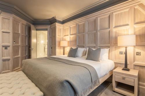 a bedroom with a large bed with wood paneled walls at The Scotsman Hotel in Edinburgh