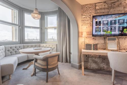 a living room with a couch and a table at The Scotsman Hotel in Edinburgh