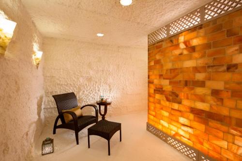 a room with two chairs and a table and a brick wall at Taj Palace, New Delhi in New Delhi