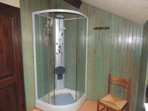 una ducha en una esquina de una habitación con silla en le chant des oiseaux, en Craponne-sur-Arzon