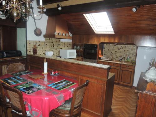 cocina con mesa y mantel rojo en le chant des oiseaux, en Craponne-sur-Arzon
