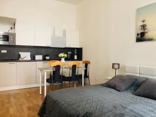 1 dormitorio con cama, mesa y cocina en Modern cozy apartment in central Prague, en Praga