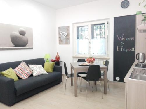 ein Wohnzimmer mit einem Sofa und einem Tisch in der Unterkunft L'Angoletto in Ciampino