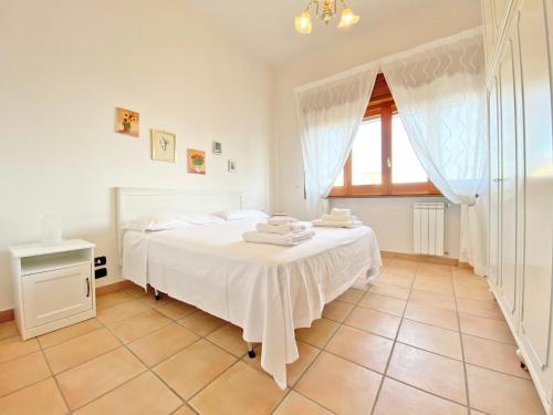 a bedroom with a white bed and a window at Giannì Holiday Home - Vesuvio/Pompei in Terzigno