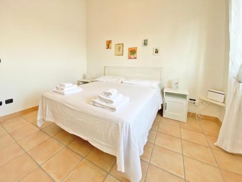 a bedroom with a white bed with towels on it at Giannì Holiday Home - Vesuvio/Pompei in Terzigno