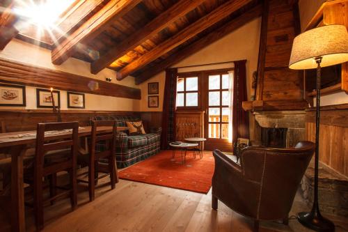 a living room with a couch and a table at Au Coeur Des Neiges Resort SPA & FREE E-BIKE in Courmayeur