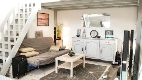 塞尼奧斯的住宿－Appartement Cosy Seignosse bord de mer，带沙发和楼梯的客厅