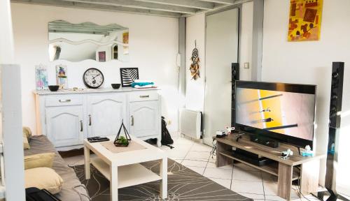 a living room with a tv and a table at Appartement Cosy Seignosse bord de mer in Seignosse