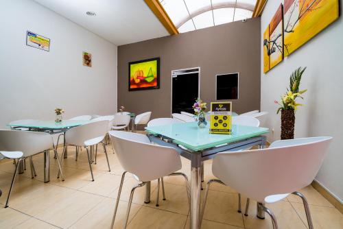 a conference room with two tables and white chairs at Ayenda 1703 Gran Reserva in Villavicencio
