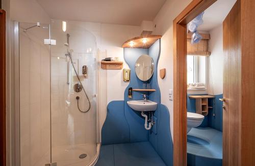 a bathroom with a sink and a toilet and a shower at Bed & Breakfast Landhaus Strasser in Söll