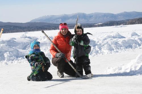 a man and two children standing in the snow at Auberge et Chalets sur le Lac in Lac-Mégantic