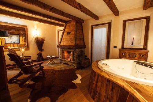 a bathroom with a bath tub and a fireplace at Au Coeur Des Neiges & SPA in Courmayeur