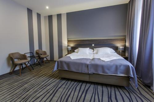 Un pat sau paturi într-o cameră la Öreg Miskolcz Hotel
