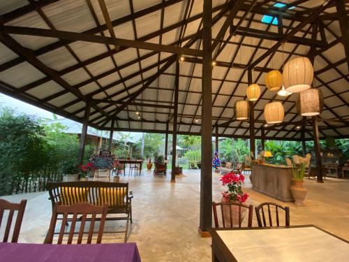 a pavilion with chairs and a table and a table and chairsktop at BaanSuk Sukhothai Resort in Sukhothai
