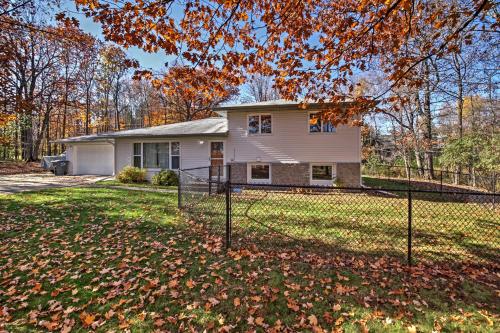 a house with a fence in front of a yard at Quaint Duluth Hideaway with Private Fenced-In Yard! in Duluth