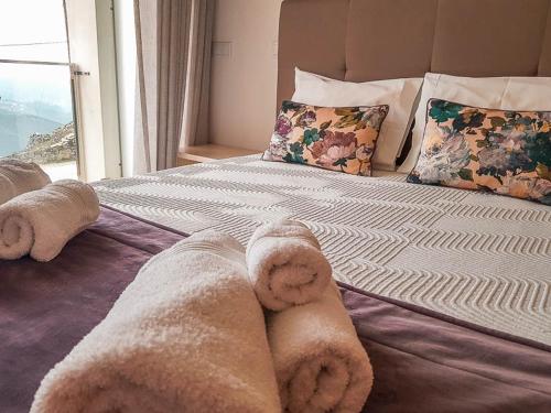 a bed with towels on it with a window at Hotel Rural da Freita in Arouca