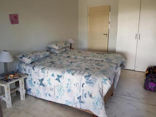 um quarto com uma cama com um edredão azul e branco em Nkumbe 7C em Ponta Malangane