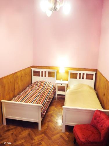 a bedroom with two beds and a chair in it at My Lovely Home In Budapest in Budapest