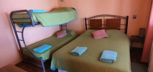 two bunk beds in a room with towels on them at Casa Chactur in San Pedro de Atacama