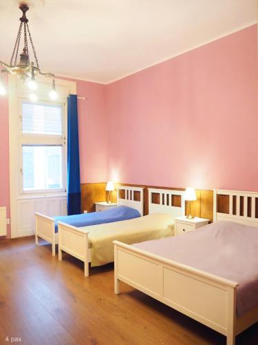 two beds in a room with pink walls at My Lovely Home In Budapest in Budapest