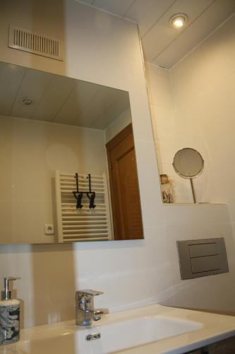 a bathroom with a large mirror over a sink at Candela's Beach Port in Masnou