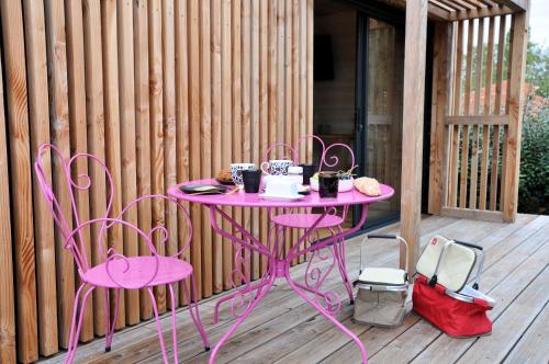 a pink table and two chairs on a deck at La Parenthèse in Bergerac