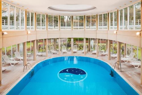 een binnenzwembad in een gebouw met een groot plafond bij Holiday Inn Resort le Touquet, an IHG Hotel in Le Touquet-Paris-Plage