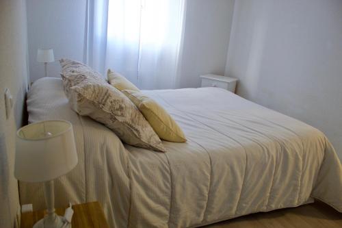 a white bed with pillows on it in a room at Appart Chrystal in Carcassonne