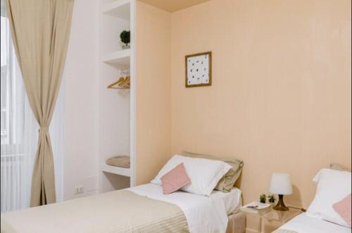 a bedroom with two beds and a clock on the wall at Charming 25 Apartment in Rome