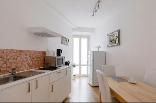 a kitchen with a table and a refrigerator at Charming 25 Apartment in Rome