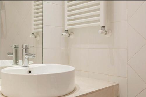 a white bathroom with a sink and a mirror at Charming 25 Apartment in Rome
