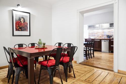 a dining room with a red table and chairs at Prime Location Apartment in Krakow