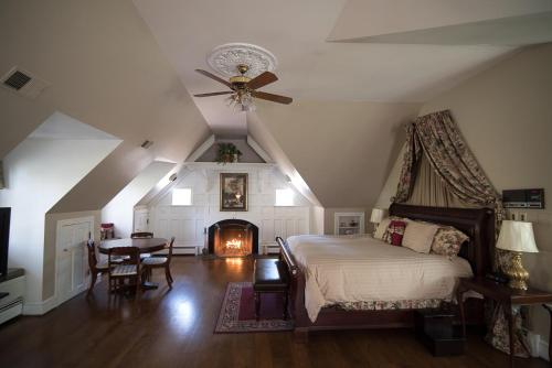 1 dormitorio con cama, mesa y chimenea en Stafford House Bed & Breakfast, en Fairfax