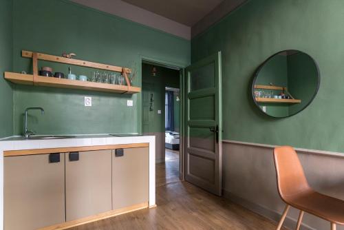 a green kitchen with a sink and a mirror at Beautiful best location apartment Green Mouse in Plovdiv