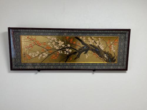 a picture of a tree with flowers on a wall at Maguro House in Osaka