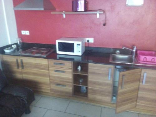 a kitchen counter with a microwave and a sink at Cowrie Luxury Beach Studio in Mombasa