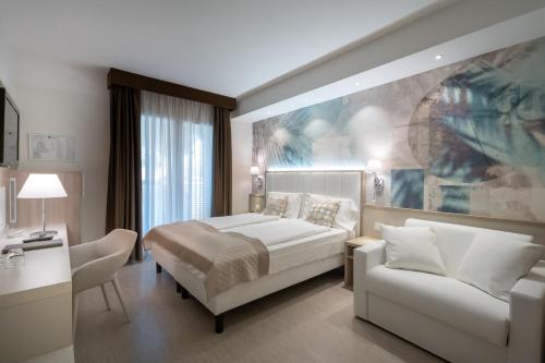 a hotel room with a bed and a couch at International Beach Hotel in Caorle