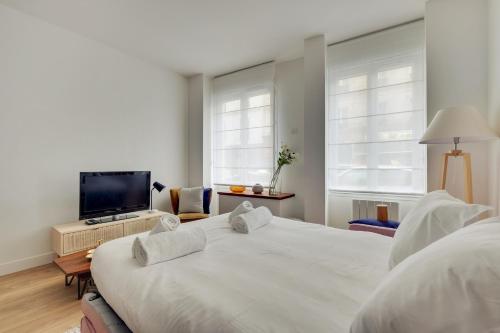 une chambre avec un grand lit et une télévision à écran plat dans l'établissement Cocooning Apt St Germain - 4 pers, à Paris