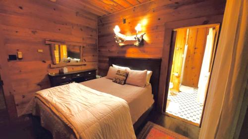 a bedroom with a bed in a wooden cabin at Lake Rabun Hotel in Lakemont