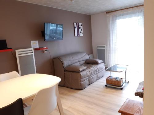 a living room with a couch and a table at Charmant T2 rénové RDC Résidence quartier pavillonnaire in Argelès-Gazost