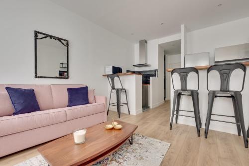 - un salon avec un canapé et quelques tabourets de bar dans l'établissement Cocooning Apt St Germain - 4 pers, à Paris