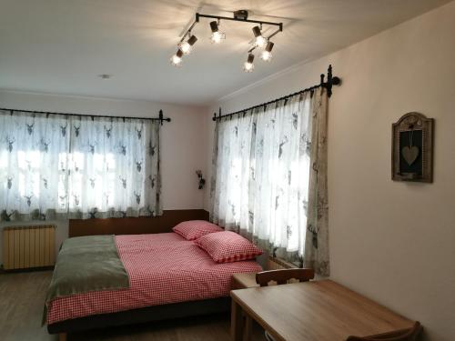 a bedroom with a bed and a table and curtains at Chalet Glockenhof in Walchsee