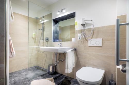 a bathroom with a sink and a toilet and a shower at Hotel Chavalatsch in Tubre