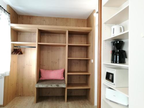 a closet with wooden shelves and a pink pillow at Chalet Glockenhof in Walchsee