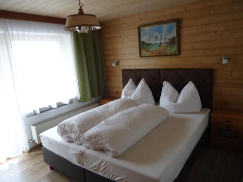 sypialnia z łóżkiem z białymi prześcieradłami i poduszkami w obiekcie Gästehaus Birkenheim w mieście Zell am Ziller